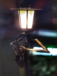 Lampione artistico con piccolo sassofono a Kazanlak illuminato di notte, Bulgaria