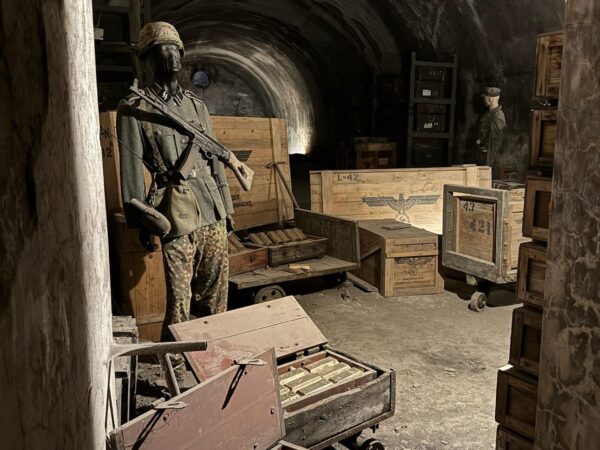 Ricostruzione storica con casse di lingotti d'oro e manichino in divisa all'interno di una galleria.