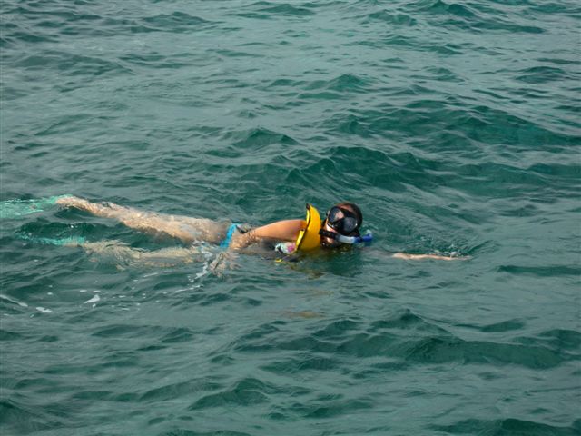Nuotatore con maschera e giubbotto di salvataggio in acqua aperta.
