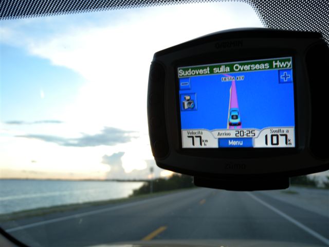 GPS in auto mostra percorso sulla strada costiera.