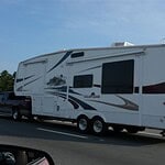 Caravan camper moderno in viaggio su strada aperta.