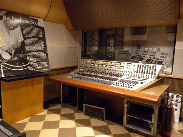Studio di registrazione con console audio e apparecchiature professionali.