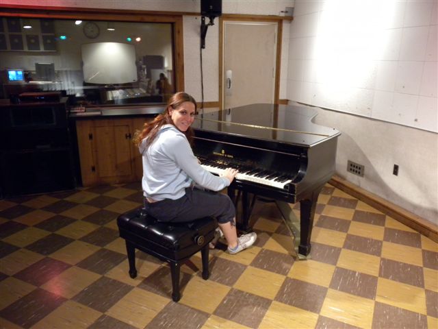 Donna che suona il pianoforte in studio di registrazione professionale.