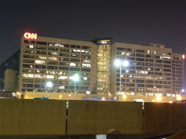 Edificio CNN illuminato di notte con logo visibile, vista notturna urbana.