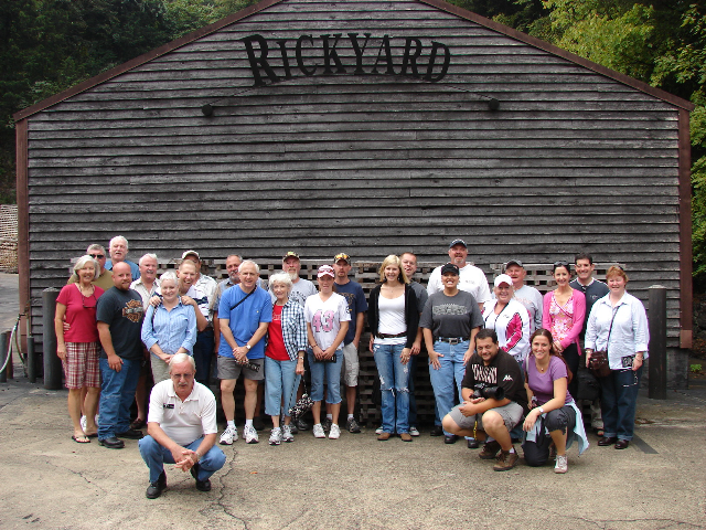 Gruppo di persone davanti a un edificio in legno con scritta 'Rockyard'.
