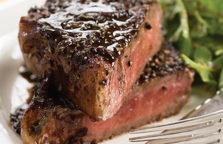 Deliziosa bistecca alla griglia con salsa e contorno di insalata fresca.