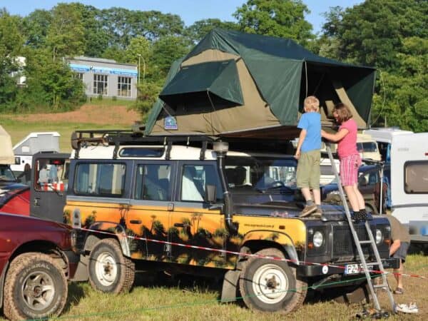 Land Rover Defender con tenda da tetto morbida aperta e bambini sulla scala, Abenteuer & Allrad 2012