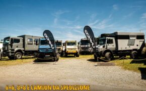 Camion da spedizione allo stand Hellgeth di Abenteuer & Allrad: MAN con cellula, Unimog blu e giallo e Unimog grigio con cellula abitativa