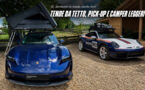 Porsche Taycan blu con tenda da tetto Porsche aperta e, accanto, una Porsche 911 Dakar con livrea Roughroads 953, allo stand Porsche di Abenteuer & Allrad