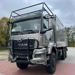 Camion militare con struttura di supporto e cabina robusta.