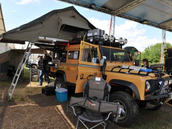 Land Rover Defender allestito con tenda da tetto in area espositiva