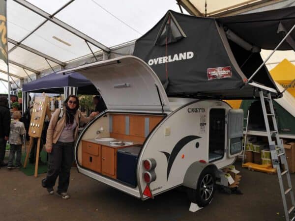 Mini caravan teardrop con tenda da tetto in area espositiva