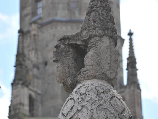 Scultura in pietra in primo piano davanti al Daniel, il campanile di St. Georg, Nördlingen