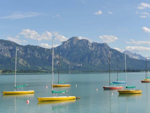 Barche a vela ormeggiate sul Forggensee, con le Alpi sullo sfondo, nei dintorni di Füssen