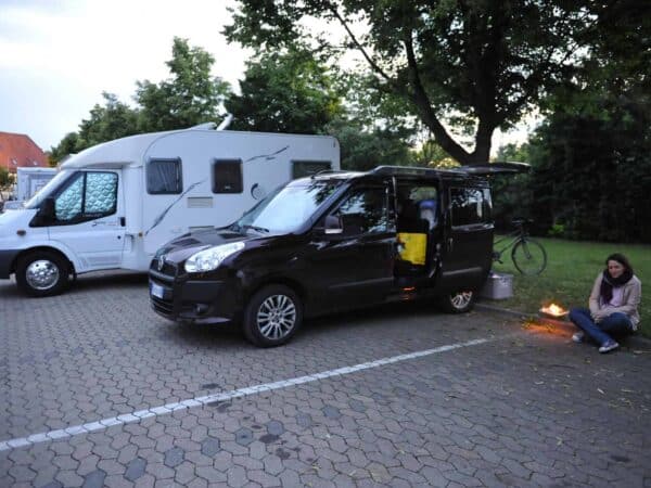 Camper e auto in sosta in un parcheggio di Nördlingen, la sera