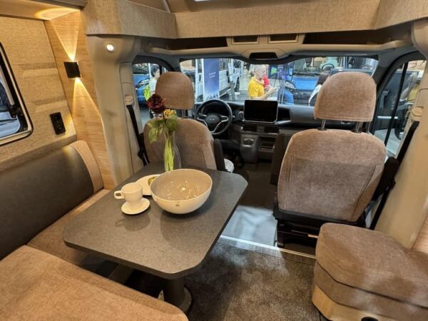 Dinette del Knaus SKY TI VW con il tavolo e, sopra la cabina, la finestra apribile in vero vetro