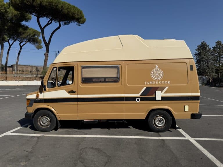 Westfalia James Cook originale su Mercedes 309 D color sabbia, con il tetto alto e la rosa dei venti sulla fiancata, fermo in un parcheggio