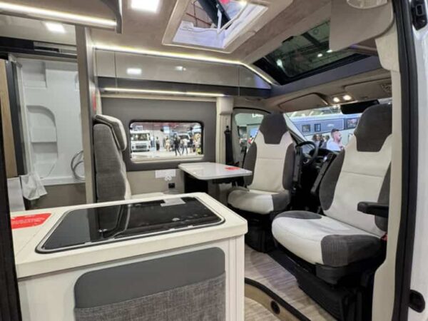 Interno dell&rsquo;Arca Mascotte 2027: cucina, dinette con i sedili girati e tetto vetrato sopra la cabina