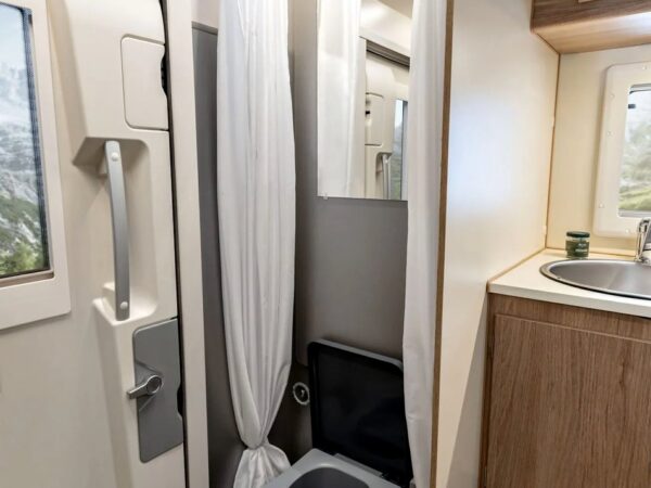 Il bagno: doccia con tenda e pedana in legno, toilette a separazione Trelino; il lavabo è fuori dal vano doccia.