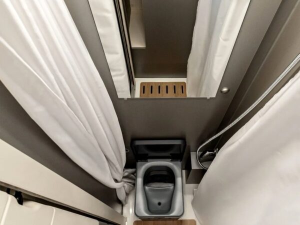 Il vano doccia visto dall'alto: piatto con pedana in legno, doccetta e toilette a separazione.