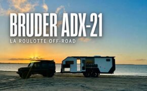 La caravan off-road Bruder ADX-21 trainata sulla spiaggia al tramonto